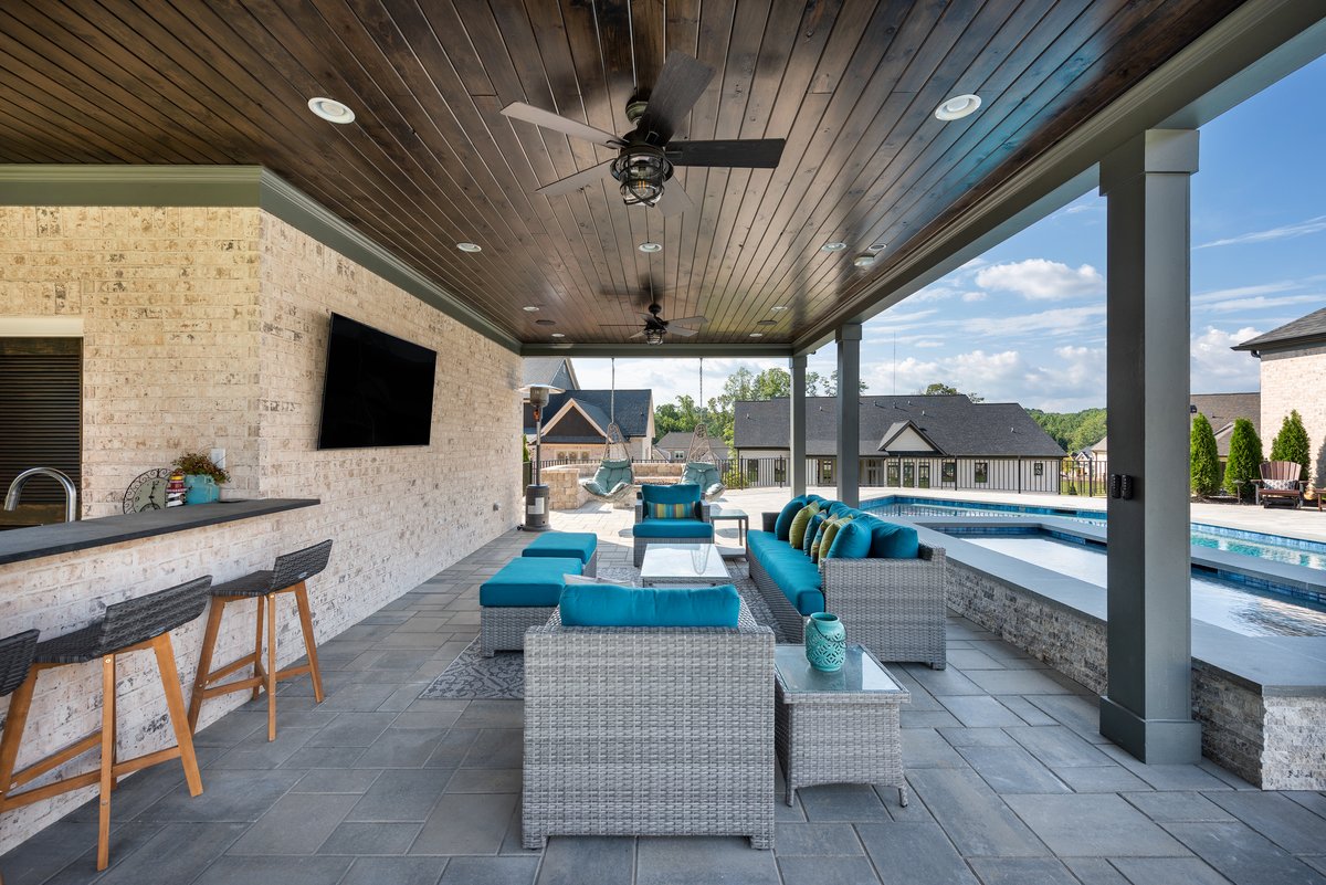 Covered outdoor kitchen and bar seating beside the pool, Braselton GA